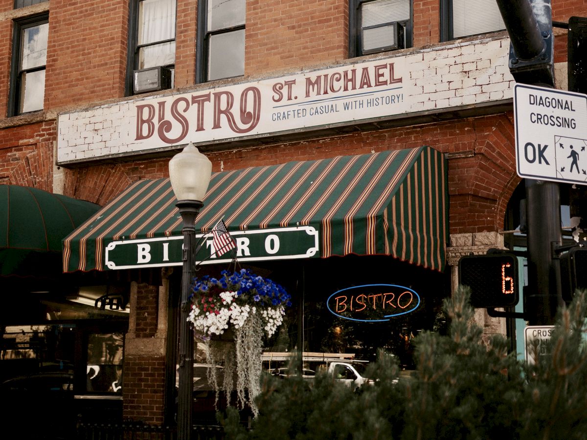 The image shows the exterior of "Bistro St. Michael" with a striped awning and an old brick facade. There is a "diagonal crossing" sign.